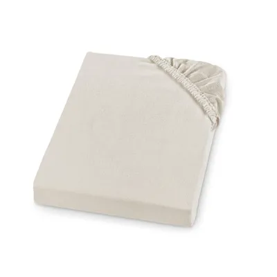 A cream-colored fitted sheet is shown lying flat on a white background.