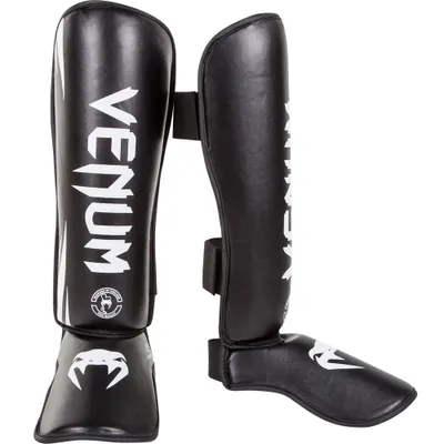 A pair of black shin and instep guards for martial arts.