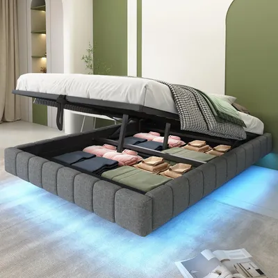 A bed with its storage compartment open, revealing folded clothes and linens. The bed frame has LED lighting underneath.