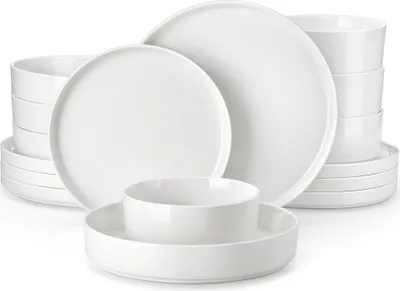 A collection of white ceramic plates and bowls stacked and arranged.
