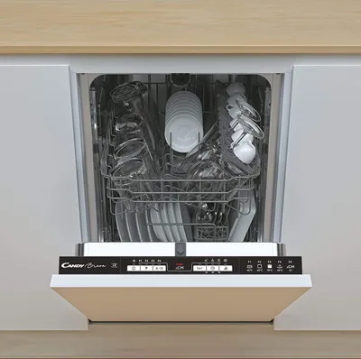 An open dishwasher filled with clean dishes, glasses, and cutlery, with the control panel visible.