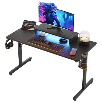 A gaming desk setup with a monitor, keyboard, mouse, headphones, and a cup holder.