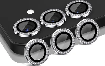 A set of six camera lens protectors with decorative rhinestones, arranged on a black surface.