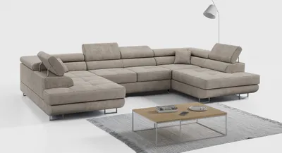 A beige sectional sofa is shown in a studio setting with a coffee table and a floor lamp.