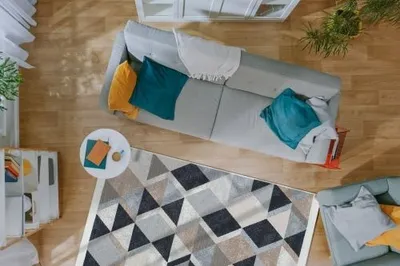 A top-down view of a living room with a sofa, rug, and coffee table.