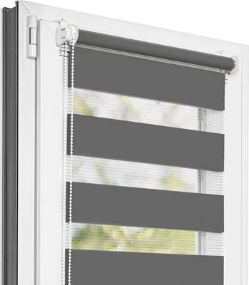 A close-up view of a dark gray and white striped roller blind installed in a white window frame.