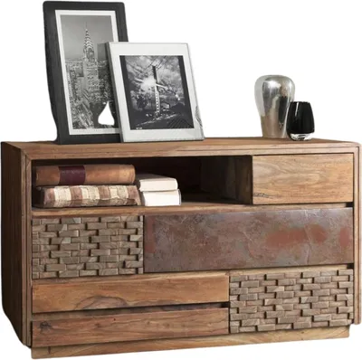 A wooden dresser with various textures and drawers, decorated with framed pictures and decorative objects.