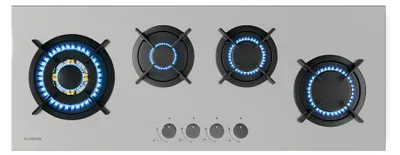A top-down view of a gas stovetop with four burners, two of which are lit with blue flames.
