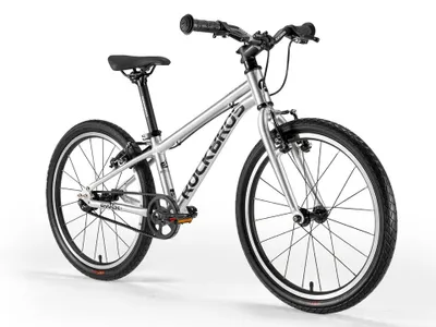 A silver children's bicycle with black tires and seat is shown against a white background.