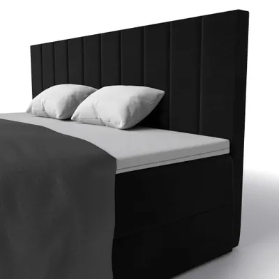 A black boxspring bed with white pillows and a dark gray blanket, shown from a side angle against a white background.
