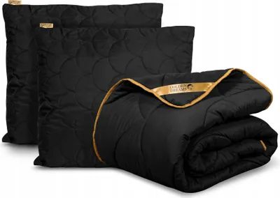 A folded comforter and two pillows are displayed on a white background.