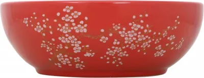 A red ceramic bowl with a cherry blossom pattern.