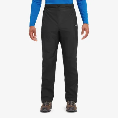 Schwarze Hardshellhosen "Solution Pants" von Montane; getragen von einem Mann in blauer Langarmoberbekleidung.