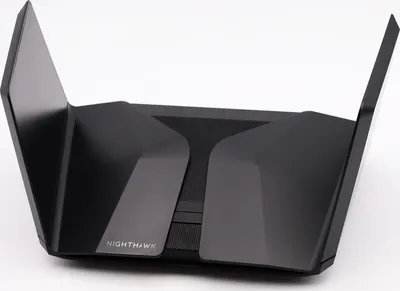 A black Netgear Nighthawk wireless router with its antennas extended, photographed against a white background.