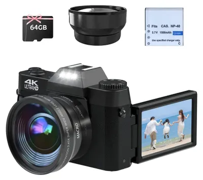 A digital camera with accessories, including a memory card, lens, and battery, displayed on a white background. The camera's screen shows a family on a beach.