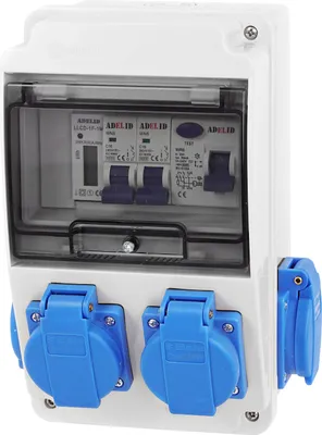 A white electrical distribution box with clear cover, showing circuit breakers and outlets.