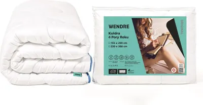 A folded white duvet is shown next to its packaging, which features a lifestyle image of a woman reading in bed.