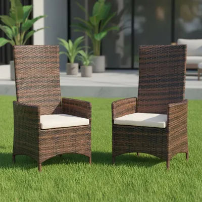 Two brown rattan chairs with cream cushions are placed on a green lawn in front of a modern building with large windows and potted plants.