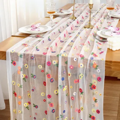 Zdjęcie produktu dla Bieżnik stołowy z białej tiulu z haftem - 72 x 300 cm, idealny do dekoracji na specjalne okazje