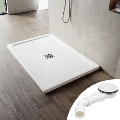 A white shower tray with a drain is shown on a wooden floor next to a tiled wall. A separate image of a drain assembly is in the bottom right corner.