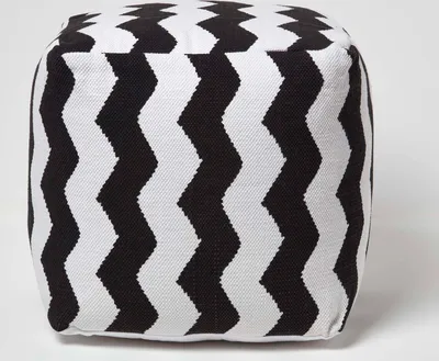 A cube-shaped pouf with a black and white chevron pattern.