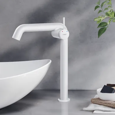 A white faucet is shown next to a white sink in a bathroom setting.