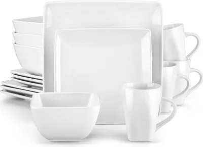 A collection of white ceramic dishes and mugs are neatly arranged on a white background.