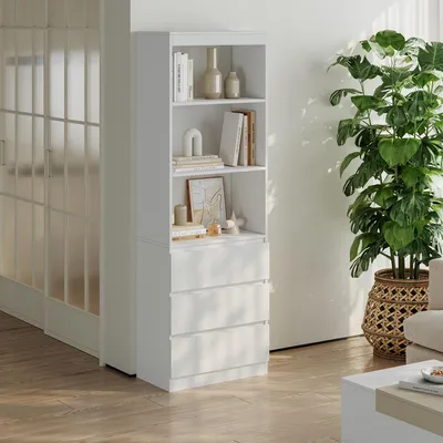 A white bookshelf with drawers is shown in a room with wooden floors and a large plant.