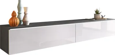A modern TV lowboard with decorative vases and a plant on top.