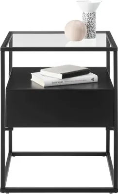 A black metal side table with a glass top, featuring two books and decorative items on top.
