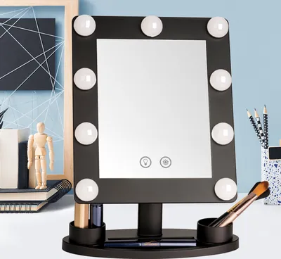 A makeup mirror with LED lights is displayed on a desk with various accessories.
