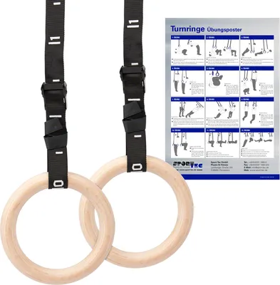 Two wooden gymnastic rings with black adjustable straps are shown hanging, with a poster of exercises in the background.