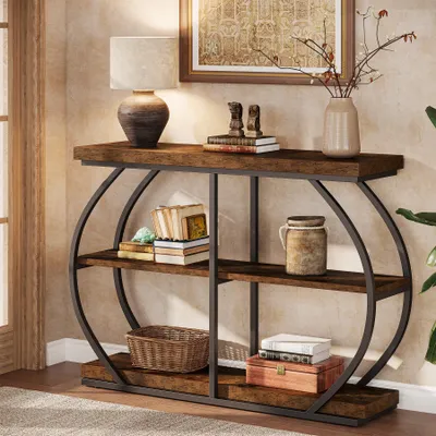 A console table with shelves is decorated with books, a lamp, a vase, and a basket.
