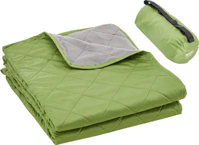 A folded green camping blanket with a gray interior is shown next to a rolled-up green blanket in a carrying bag.