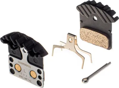 A set of bicycle disc brake pads and associated hardware, laid out on a white background.