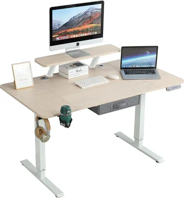A standing desk with a monitor, laptop, keyboard, mouse, and accessories.
