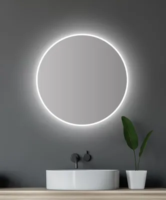 A modern bathroom vanity with a round LED mirror, a white sink, and black faucets.
