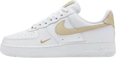 A side view of a white Nike Air Force 1 '07 Essential sneaker with tan and gold accents.