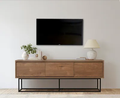 A modern living room setup featuring a TV mounted on the wall above a wooden media console.