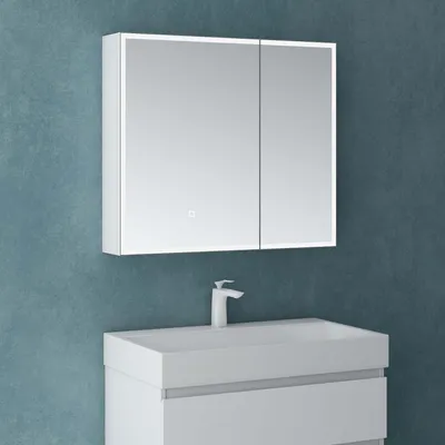 A white bathroom vanity with a sink and a mirrored cabinet with LED lighting against a blue textured wall.