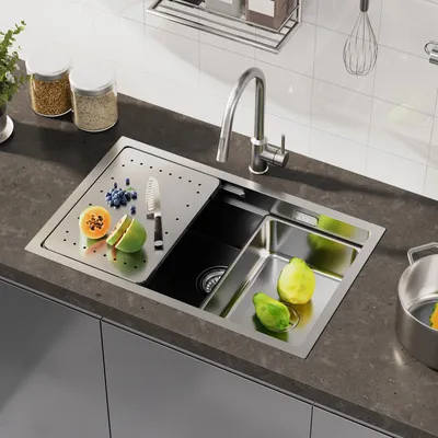 A modern kitchen sink with a faucet, cutting board, and fruit.