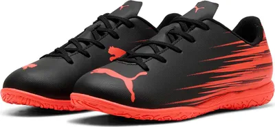 A pair of black and red Puma indoor soccer shoes for children.