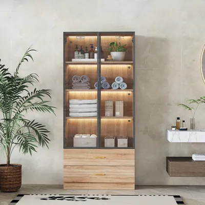 A bathroom cabinet with glass doors and LED lighting, displaying towels and toiletries.