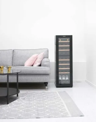 A living room setting with a sofa, coffee table, and a wine cooler.
