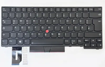 A black keyboard with a red trackpoint, shown from a top-down perspective against a white background. Cables are attached to the bottom left.