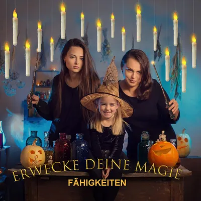 Three people dressed as witches, with a young girl in the foreground wearing a witch hat, surrounded by floating LED candles and Halloween decorations.