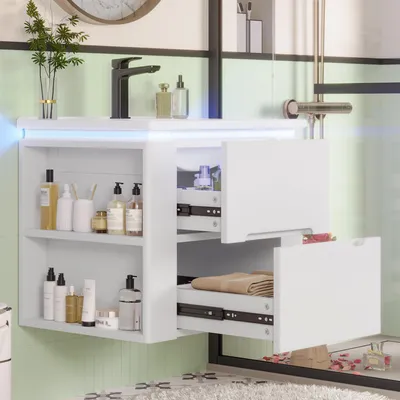 A white bathroom vanity with two drawers and open shelves, displaying various toiletries and towels. The vanity is mounted on a light green tiled wall.
