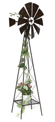 A decorative metal windmill with plants and flowers.