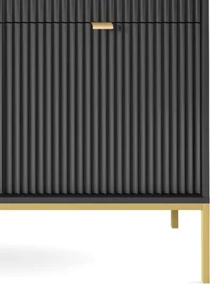 A close-up view of a black dresser with a fluted front and a gold handle.