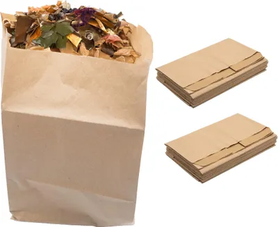 A brown paper bag filled with compostable material is shown next to two stacks of brown paper bags.